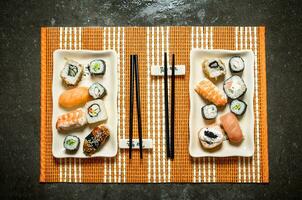 Sushi e rolos com frutos do mar em uma bambu ficar em pé. foto