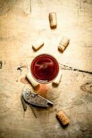 vidro do vermelho vinho com rolhas e uma saca rolhas. foto