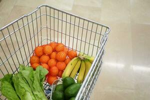 carrinho de compras cheio de comida no supermercado foto