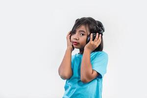 menina ouvindo música em fones de ouvido sem fio. foto