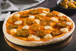 pizza com picles e mozzarella em uma de madeira borda em a mesa foto