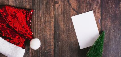 presente lista, Natal árvore e santa claus chapéu em mesa topo Visão rede bandeira foto
