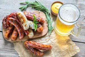 salsichas grelhadas com copo de cerveja foto