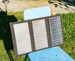 cobrando uma portátil solar bateria a partir de a Sol às uma verão acampamento local. limpar \ limpo energia para acampamento usar. foto