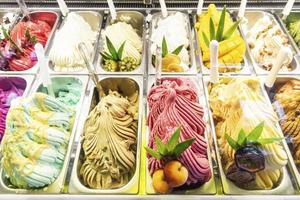vários sabores de sorvete de gelato italiano em vitrine de loja moderna foto