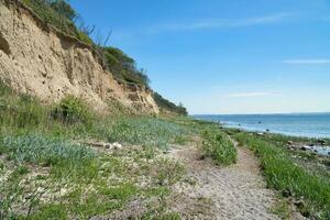 ilha poel em a íngreme costa para a báltico mar. romper Beira em a declive foto