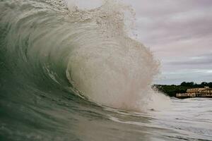 uma ampla onda quebra em a costa foto