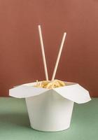 abriu a caixa de papel wok com macarrão e pauzinhos para o design do mock up foto