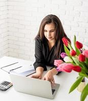florista jovem morena de negócios usando laptop no escritório foto