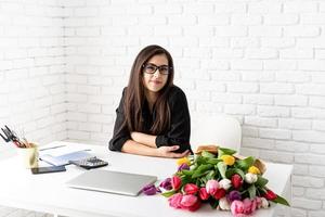 morena mulher de negócios trabalhando com flores no escritório foto