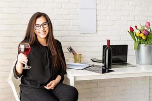 mulher de negócios bebendo vinho, comemorando no escritório foto