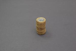 pilha de 1 moedas reais isoladas em fundo preto. foto