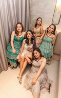 uma grupo do ásia mulheres dentro luxuoso vestidos estão esperando para jantar dentro uma hotel salão de baile foto