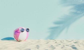 bola com óculos de sol na areia da praia foto