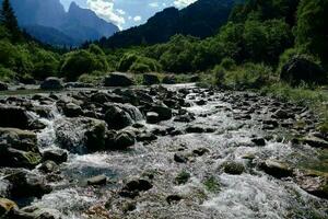 uma rio fluindo através uma rochoso montanha vale foto