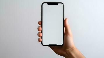 masculino mão segurando uma telefone com uma branco tela em uma cinzento fundo ai generativo foto