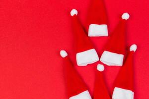 vista superior de chapéus de Papai Noel vermelhos sobre fundo colorido. conceito de feliz natal com espaço de cópia foto