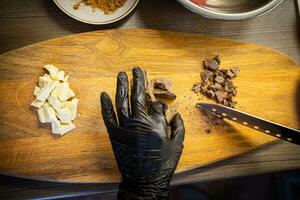 mulher cozinhando saboroso derretido chocolate em mesa dentro cozinha. foto