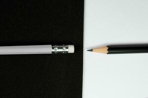 de madeira lápis, Preto lápis virar lápis cabeça para borracha do branco lápis com Preto e branco fundo, contraste conceito, escola e escritório conceito. foto