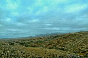 esvaziar misterioso montanhoso panorama a partir de a Centro do a canário ilha espanhol fuerteventura com uma nublado céu foto