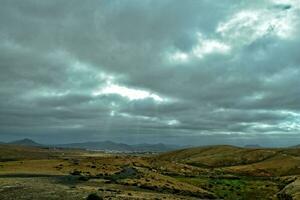 esvaziar misterioso montanhoso panorama a partir de a Centro do a canário ilha espanhol fuerteventura com uma nublado céu foto