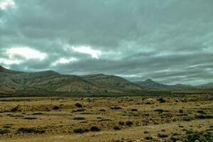 esvaziar misterioso montanhoso panorama a partir de a Centro do a canário ilha espanhol fuerteventura com uma nublado céu foto