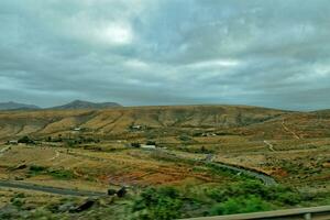 esvaziar misterioso montanhoso panorama a partir de a Centro do a canário ilha espanhol fuerteventura com uma nublado céu foto