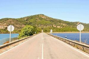 uma grandes esvaziar estrada com uma lago dentro a fundo foto