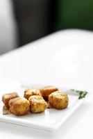 purê de batata frita, croquetes quadrados, acompanhamento vegetariano simples em prato branco foto