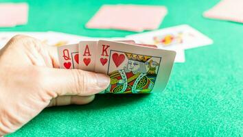 fechar-se, seletivo foco, do homem mão segurando cartões dentro rummy jogar Além disso chamado cartão jogo. borrado fundo foto