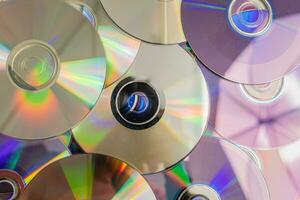 muitos velho cds representar tecnologia a partir de a anos 90. pilhas do CDs, velho canções e velho filmes. que teve fui usava antes e colocada em uma branco mesa. fechar-se, seletivo foco foto