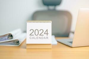 2024 ano calendário em mesa fundo. contagem regressiva, feliz Novo ano, resolução, metas, plano, Ação, missão e financeiro conceito foto