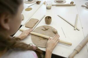 mestre classe dentro argila modelagem. uma Adolescência menina esculpe a partir de argila. foto