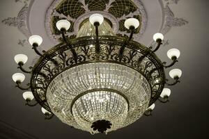 lá é uma lindo teatro lustre em a teto e a caro vidro lâmpada. foto