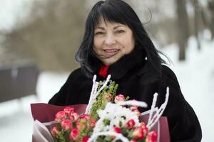 lindo idosos mulher com uma ramalhete do flores foto