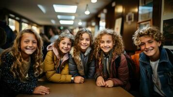 retrato do sorridente cinco escolares sentado às mesa dentro corredor às escola. foto