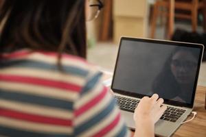 tela de espaço em branco, mulher asiática freelance esperando para iniciar o laptop. foto