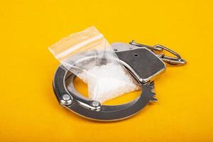 punição para tráfico de drogas, prisão de algemas de traficantes e cristais de anfetamina mefedrona. foto