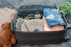 arranjo do roupas e acessórios dentro uma mala, viagem conceito. foto