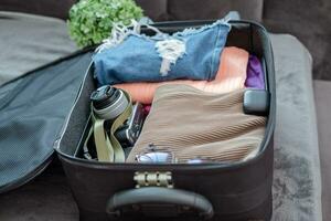 arranjo do roupas e acessórios dentro uma mala, viagem conceito. foto