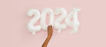 2024 Novo ano conceitos. senhoras mão holdind inflável balão números. foto