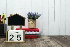 Junho 25 calendário encontro texto em branco de madeira quadra uma mesa. foto