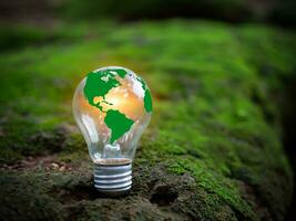 conceito do renovável energia, de Meio Ambiente proteção, e sustentável renovável energia fontes. verde mundo mapa em uma luz lâmpada conjunto em uma fundo com verde musgo. verde energia. foto