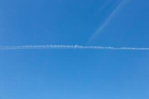 branco trilha a partir de a avião contra a azul céu. foto