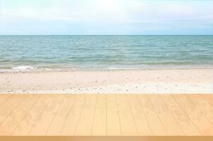 em branco de madeira mesa com branco areia de praia e mar panorama fundo para produtos exibição montagem foto