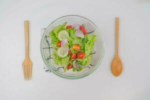 cozinhando - mulher fazer fresco orgânico vegetal salada dentro a cozinha. fêmea mãos preparando delicioso saudável Comida às lar, mistura legumes dentro uma tigela, fechar-se. foto