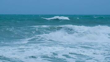 vista das ondas do mar na praia dos mares tropicais na tailândia. fortes ondas do mar atingem a costa na estação chuvosa. belas ondas do mar com espuma de cor azul e turquesa. foto