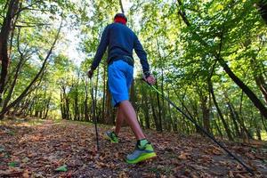 um homem praticando caminhada nórdica na floresta de outono entre as folhas foto