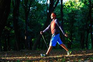 caminhada nórdica na floresta de outono entre as folhas foto