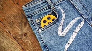 jeans e uma fita métrica. conceito de emagrecimento ou costura jeans foto